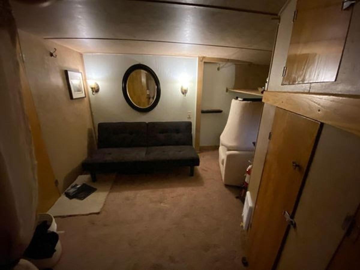a room with a couch and a mirror aboard 1986 CUSTOM SEA TREK PASSENGER VESSEL Yacht for Sale