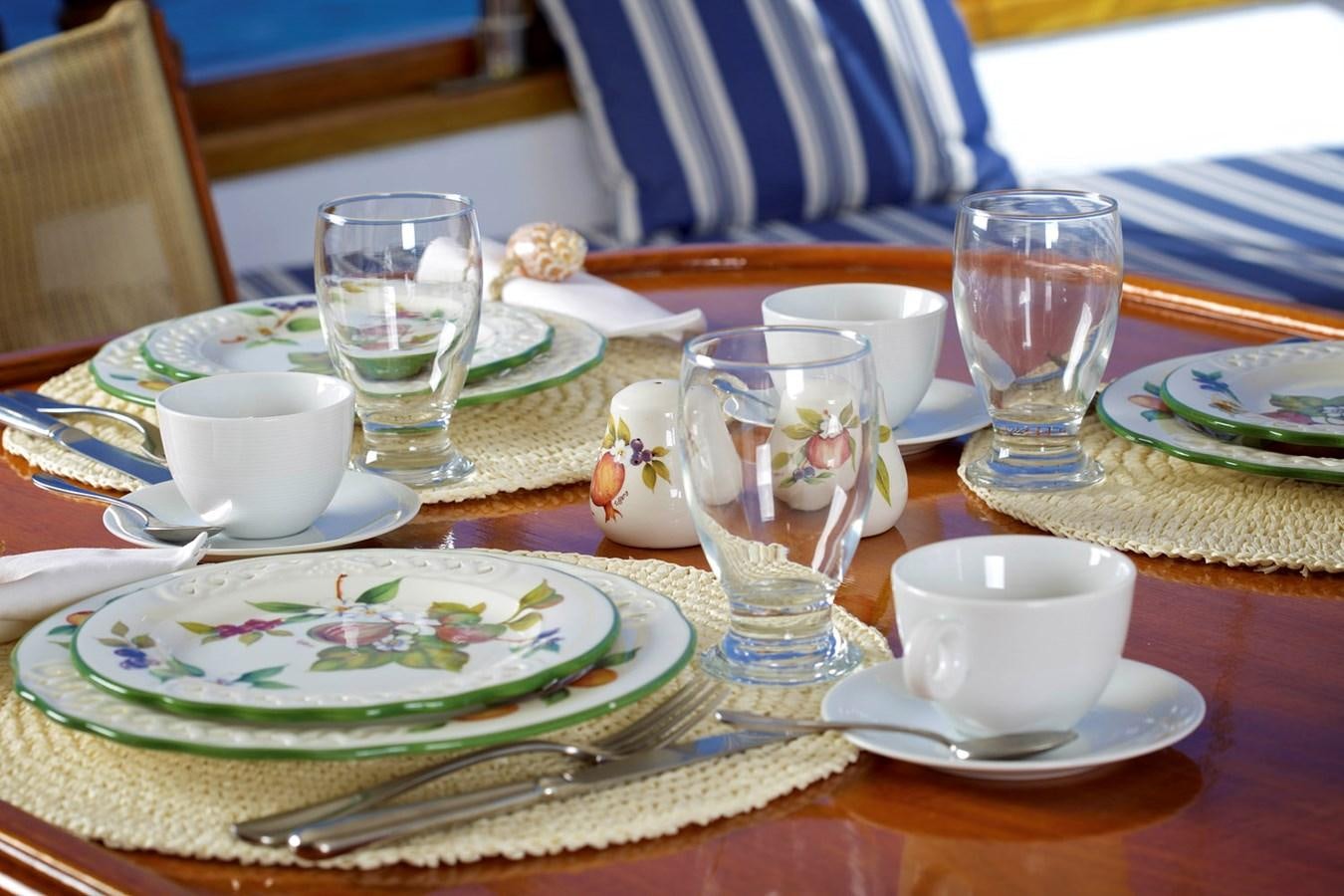 a table with plates and glasses aboard HERMINA Yacht for Sale