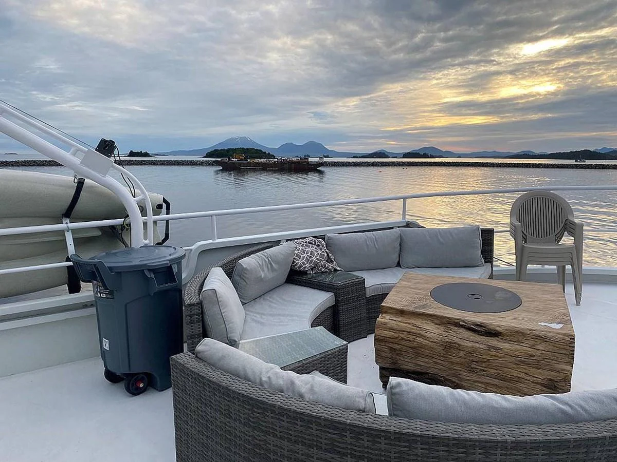 a living room with a couch and a table and a large body of water aboard BEAR PAW Yacht for Sale