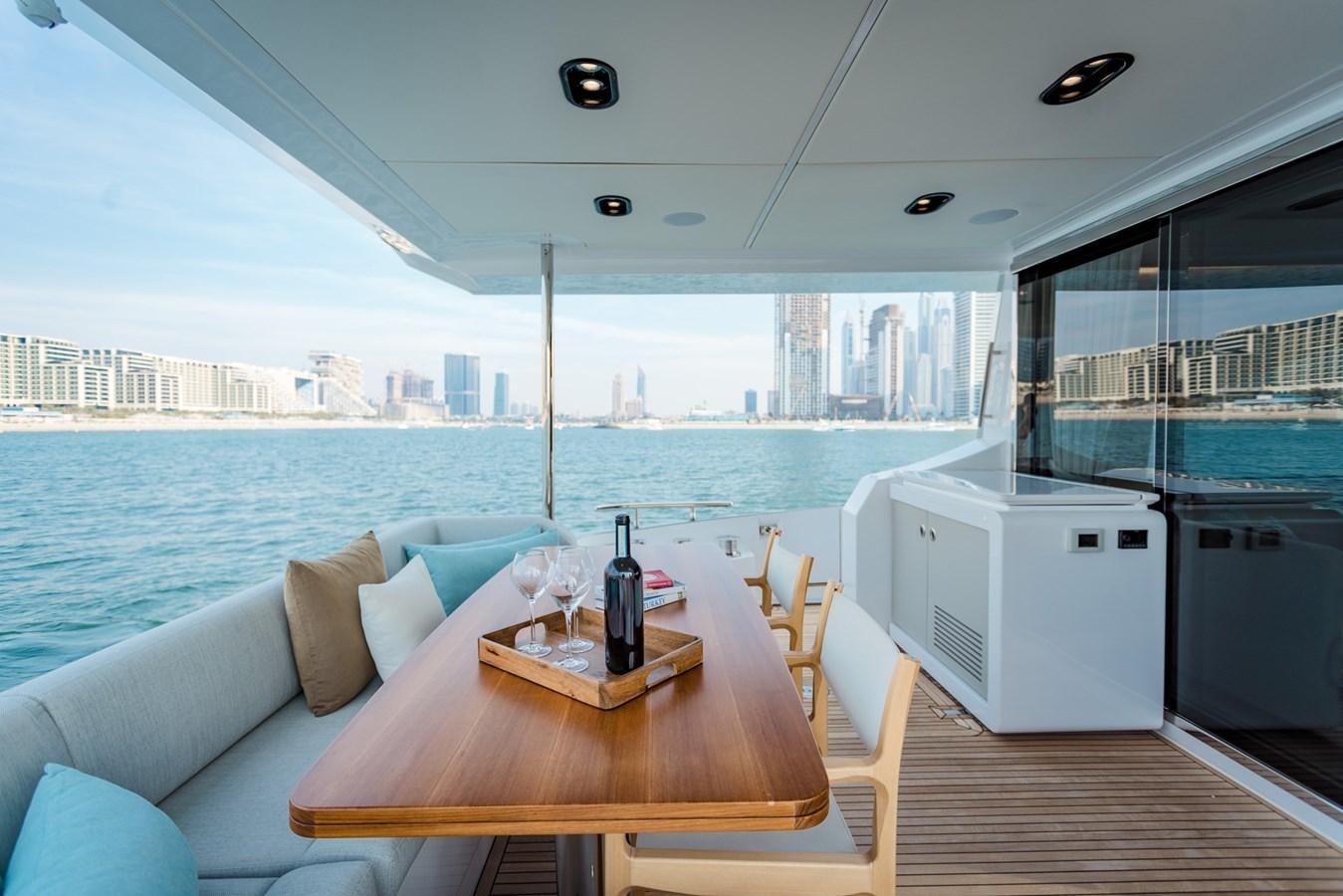 a table and chairs on a deck overlooking a large body of water aboard ATLANTIS Yacht for Sale