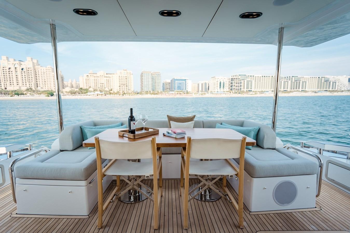a table and chairs on a deck overlooking a city aboard ATLANTIS Yacht for Sale