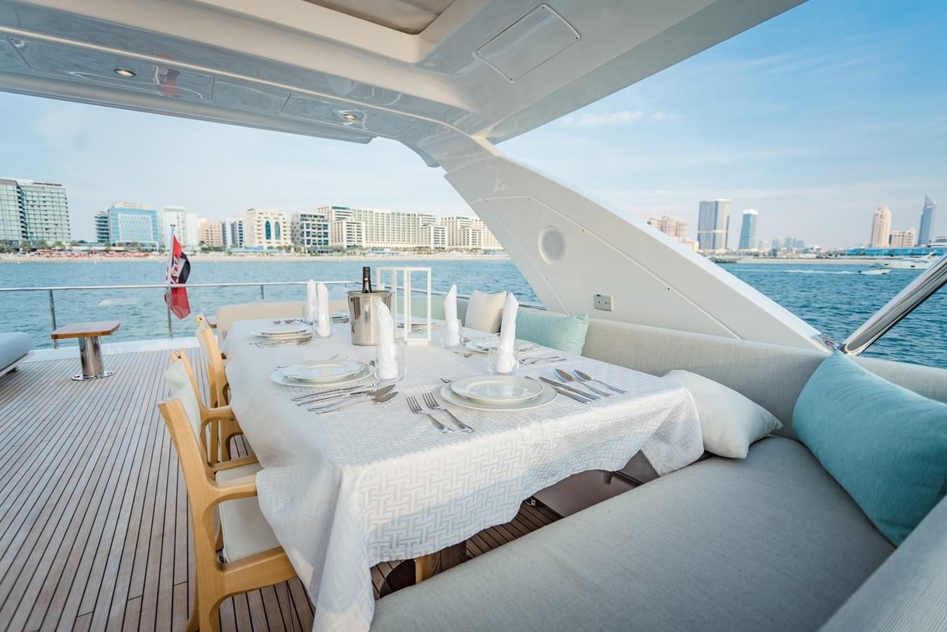a table set for a meal on a deck overlooking a large city aboard ATLANTIS Yacht for Sale