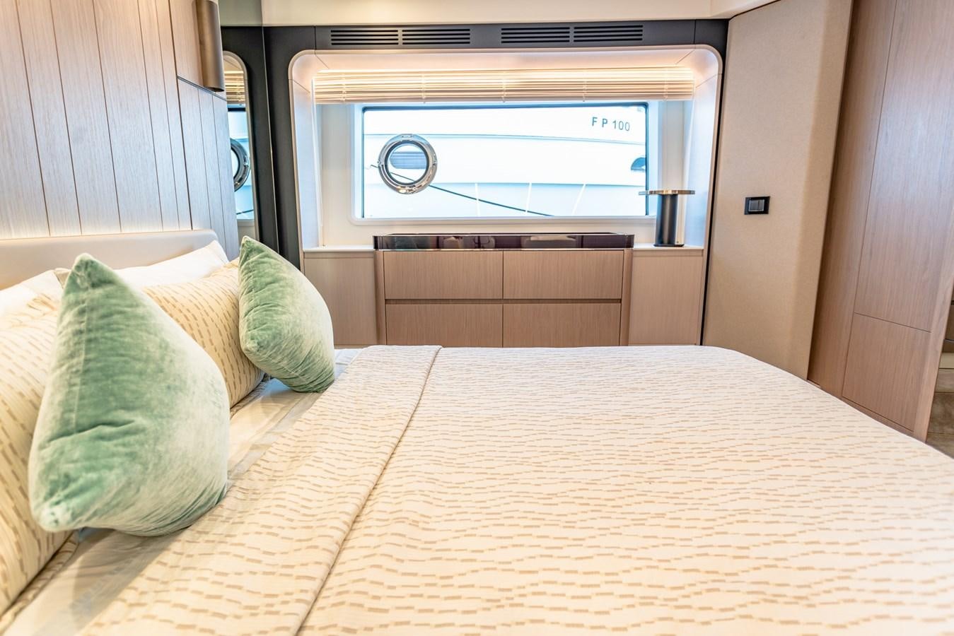 a bed with pillows and a television in the background aboard ATLANTIS Yacht for Sale