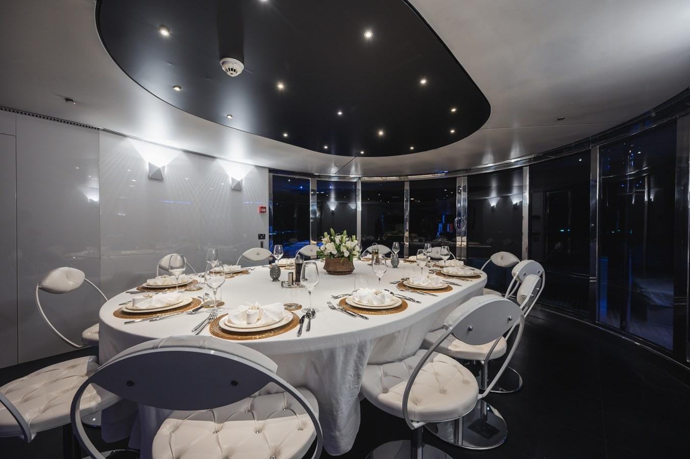 a large white table with plates and chairs aboard NONNI II Yacht for Sale