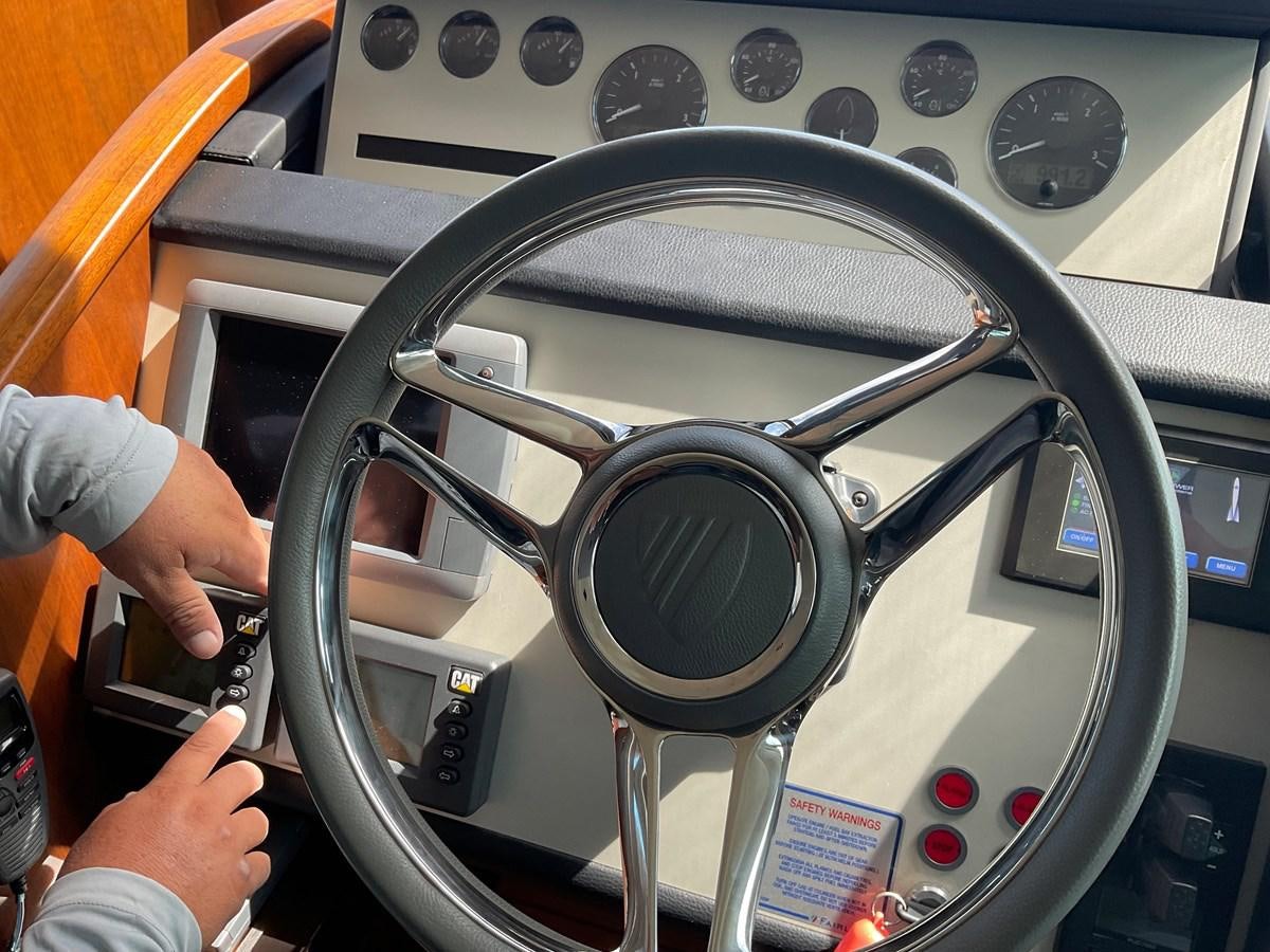 a hand holding a steering wheel aboard SQUADRON 78 CUSTOM Yacht for Sale