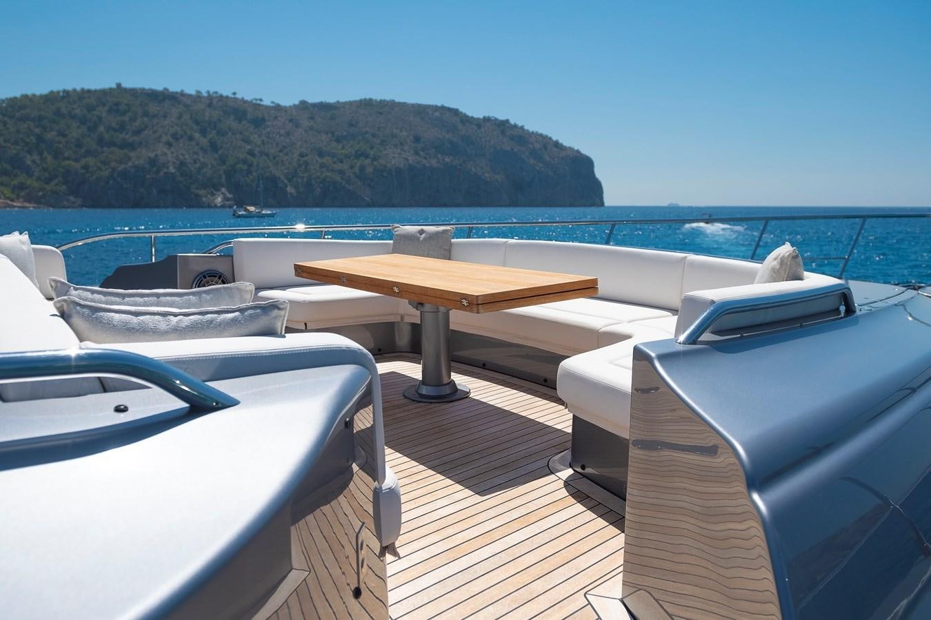 a deck with a table and chairs on it aboard BOMBADIL III Yacht for Sale