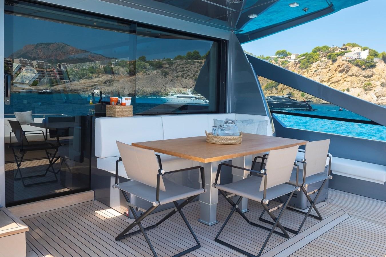 a table and chairs on a deck aboard BOMBADIL III Yacht for Sale