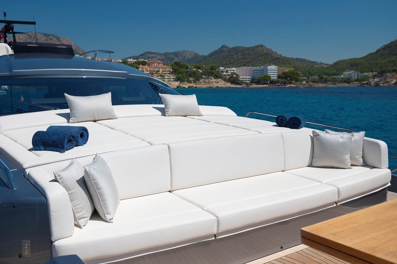 a white couch with pillows on a boat in the water aboard BOMBADIL III Yacht for Sale