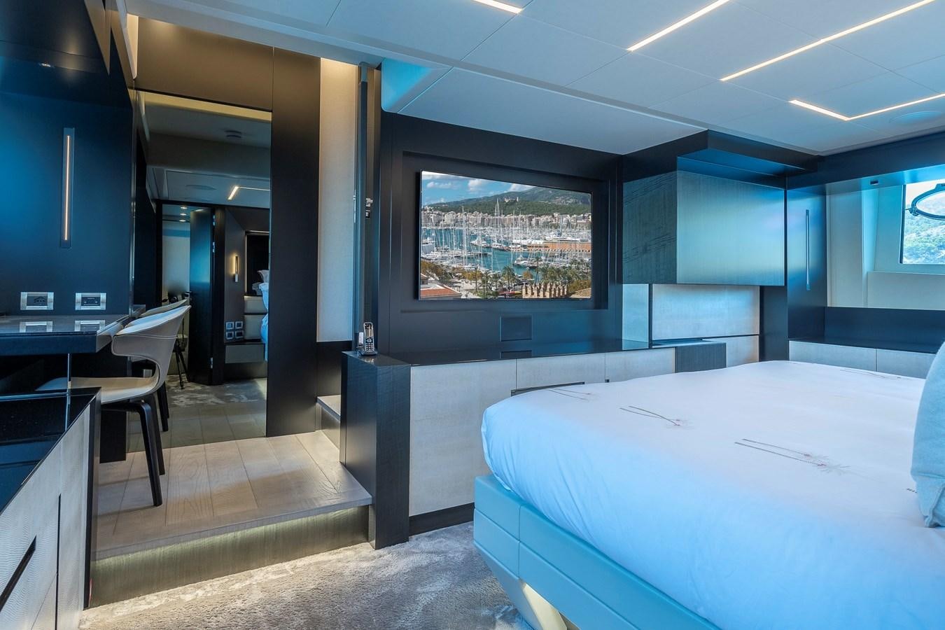 a room with a bed and desk aboard BOMBADIL III Yacht for Sale