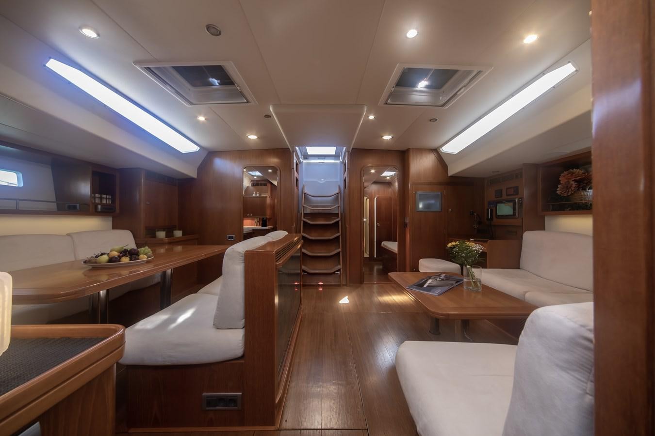 a room with a staircase and couches aboard TURCONERI Yacht for Sale