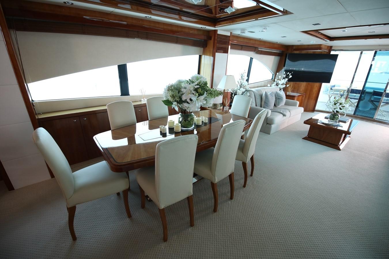 a dining table and chairs in a room with a couch and a window aboard 2008 SUNSEEKER 90 Yacht for Sale