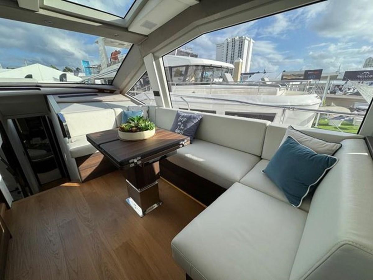a room with a couch and a table and a window aboard AICON 66 VIVERE Yacht for Sale