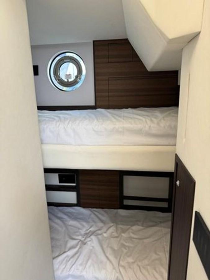a bed with a white sheet and a round mirror above it aboard AICON 66 VIVERE Yacht for Sale