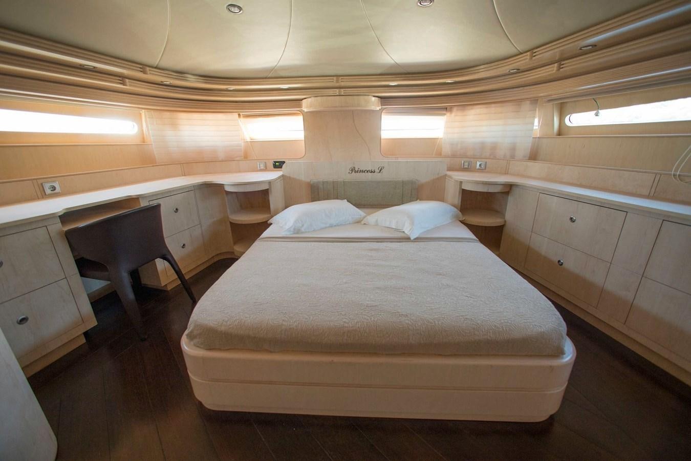 a room with a bed and desk aboard PRINCESS L Yacht for Sale