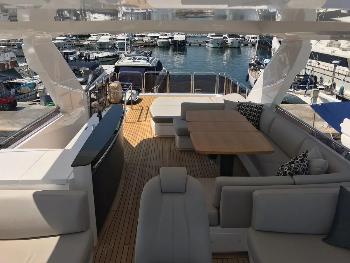 a room with a couch and a table with chairs on it aboard ANIKO Yacht for Sale