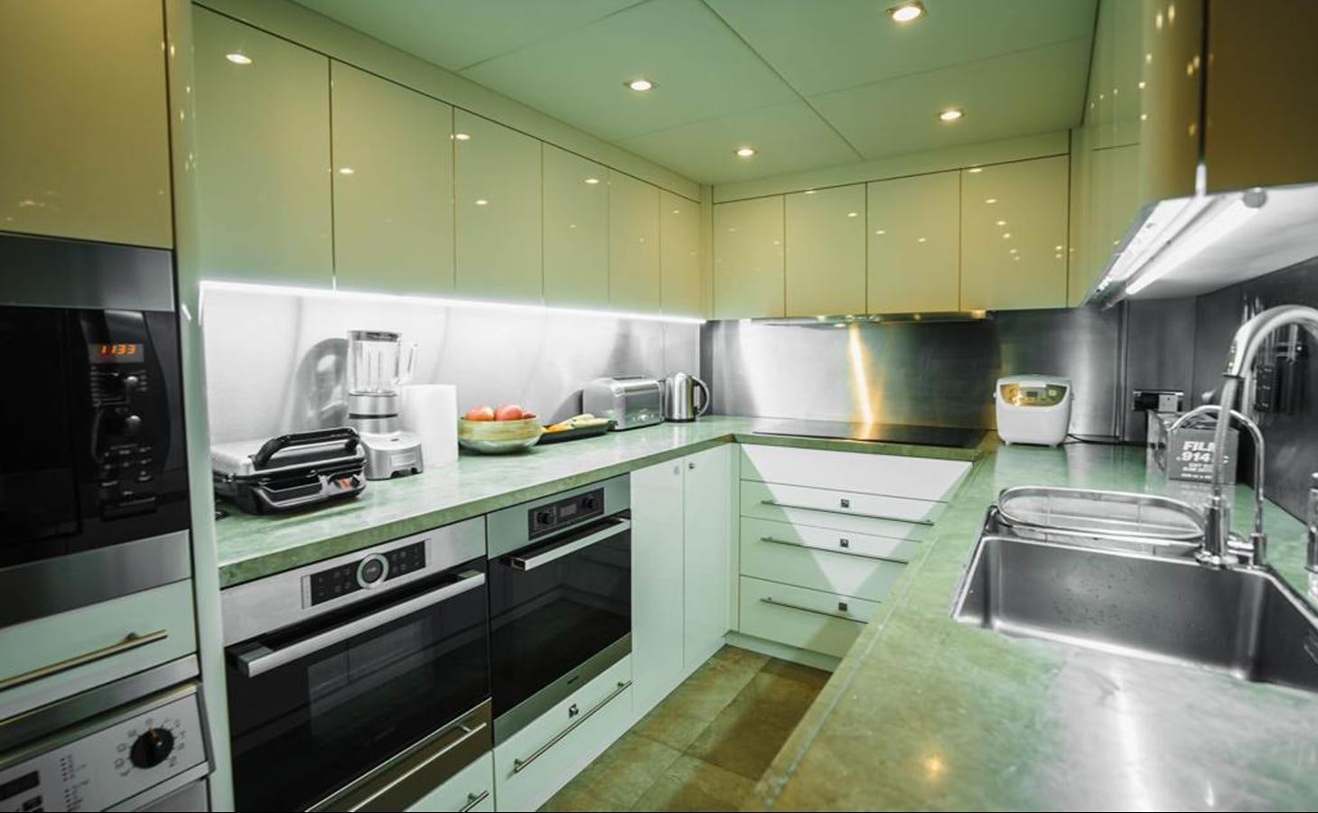 a kitchen with green cabinets aboard 2010 SUNSEEKER 40M Yacht for Sale