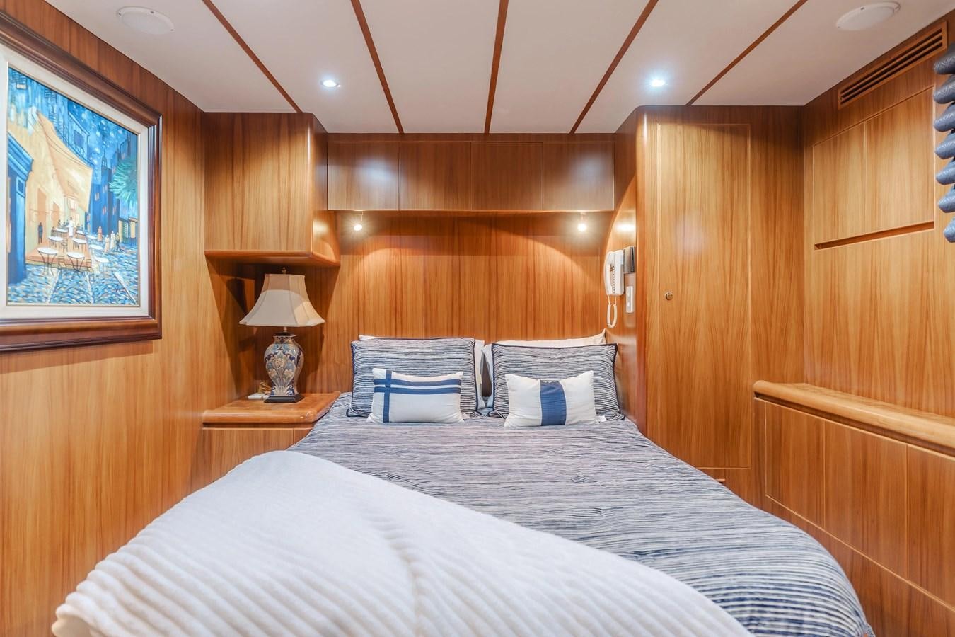 a bed with a white sheet and pillows in a wooden room aboard MONEY CAT Yacht for Sale