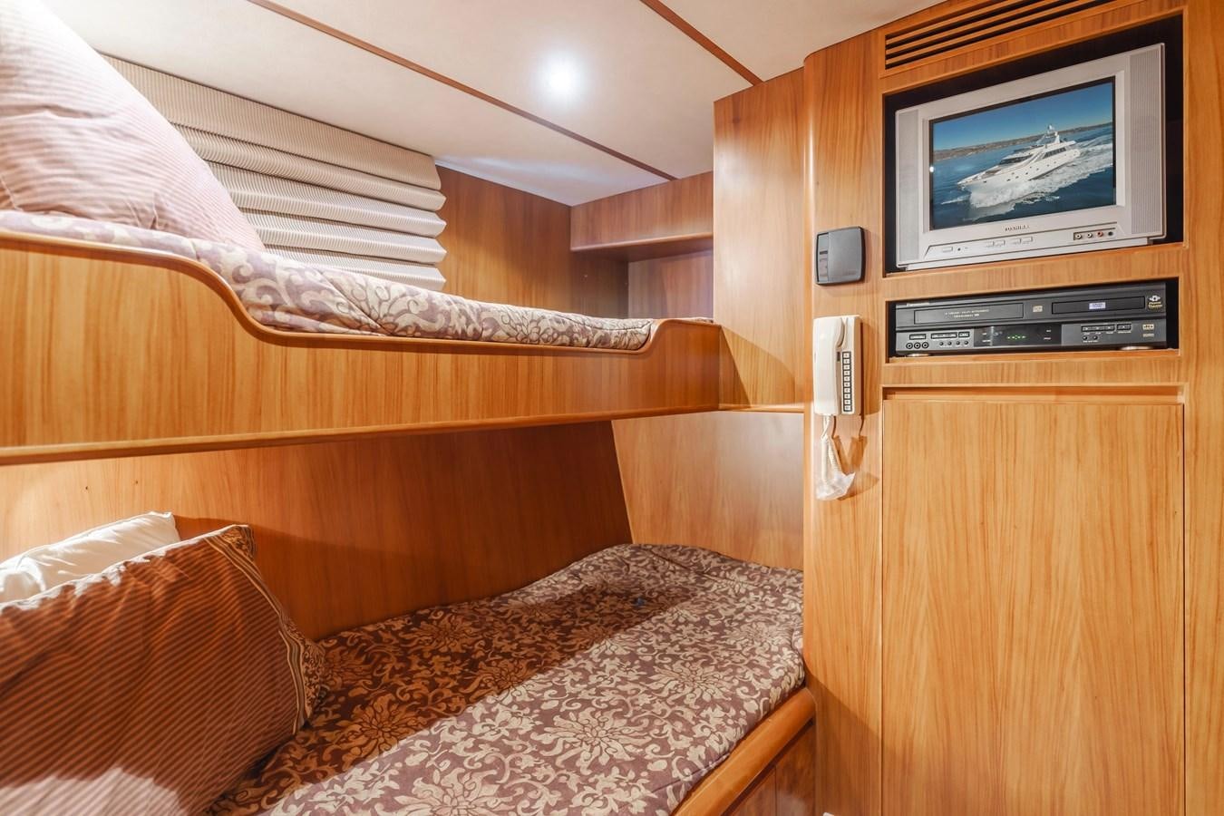 a bed with a television on the wall aboard MONEY CAT Yacht for Sale