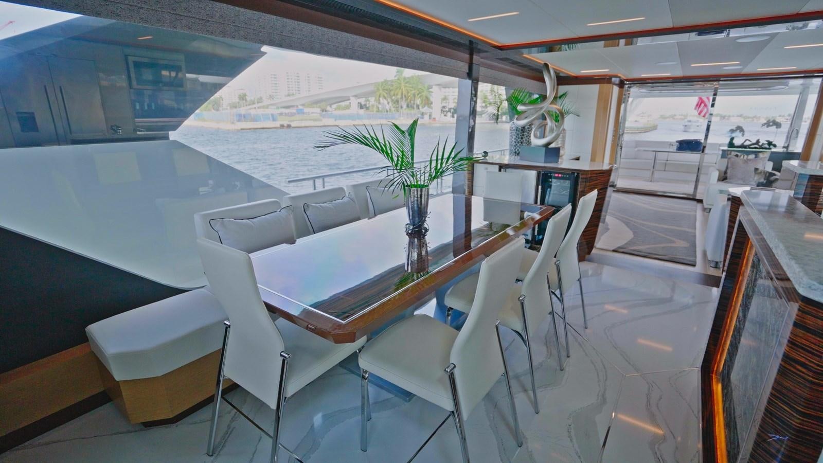 a room with white chairs and a table with plants on it aboard PANACEA Yacht for Sale