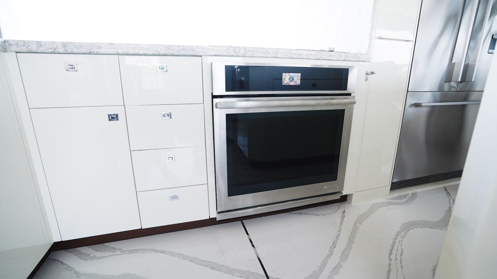 a white kitchen with a black microwave aboard PANACEA Yacht for Sale