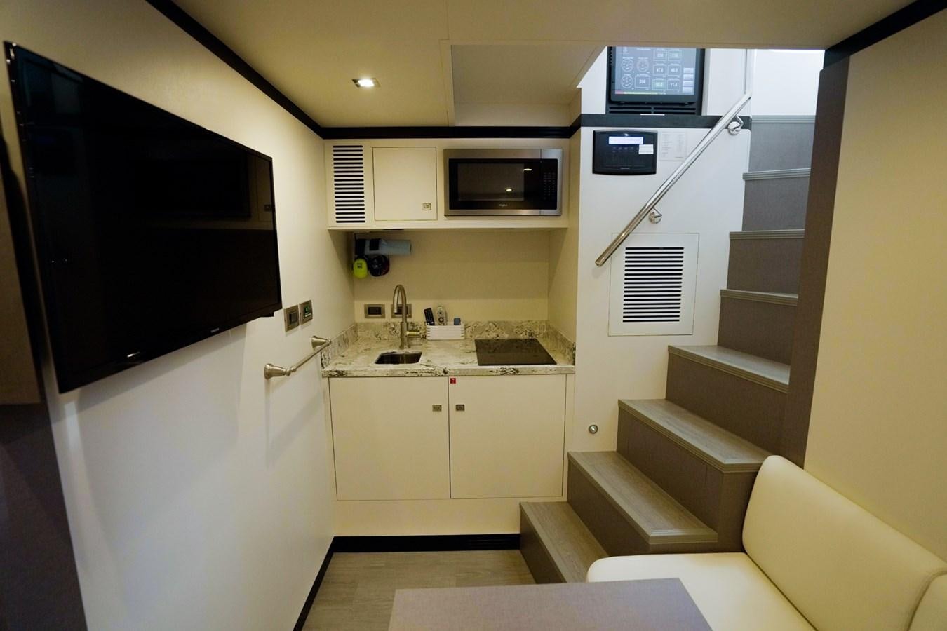 a kitchen with a staircase and a tv aboard PANACEA Yacht for Sale