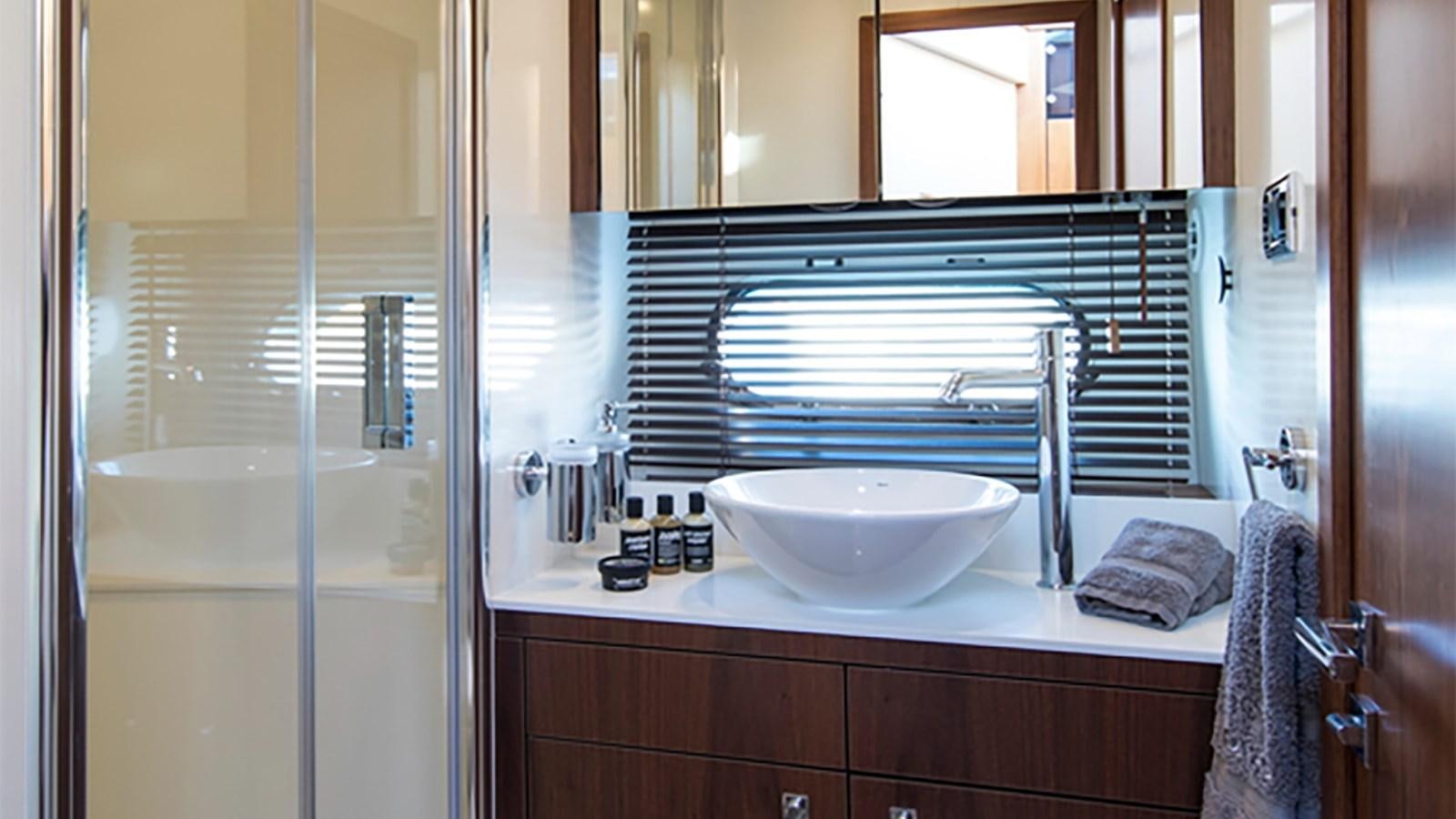 a bathroom with a sink and a large mirror aboard CARDANO Yacht for Sale