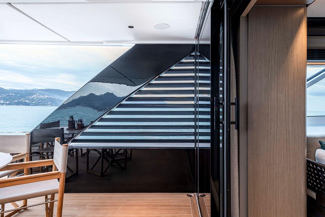 a large glass door with a view of the ocean and mountains aboard FERRETTI  INFYNITO 90 Yacht for Sale