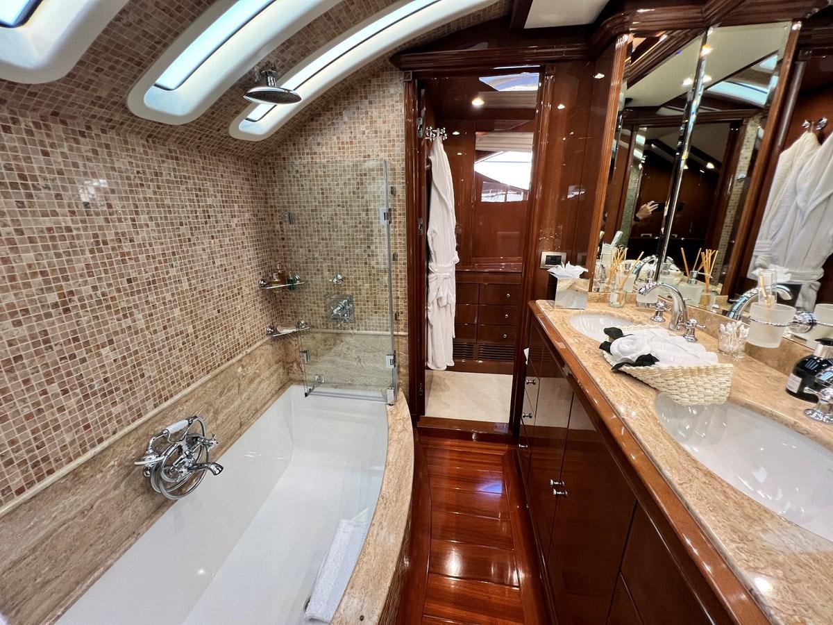 a bathroom with a bathtub and sinks aboard 2009 BENETTI 85 LEGEND Yacht for Sale