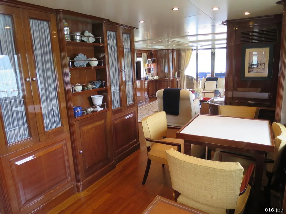 a room with a table chairs and cabinets aboard BLU Yacht for Sale