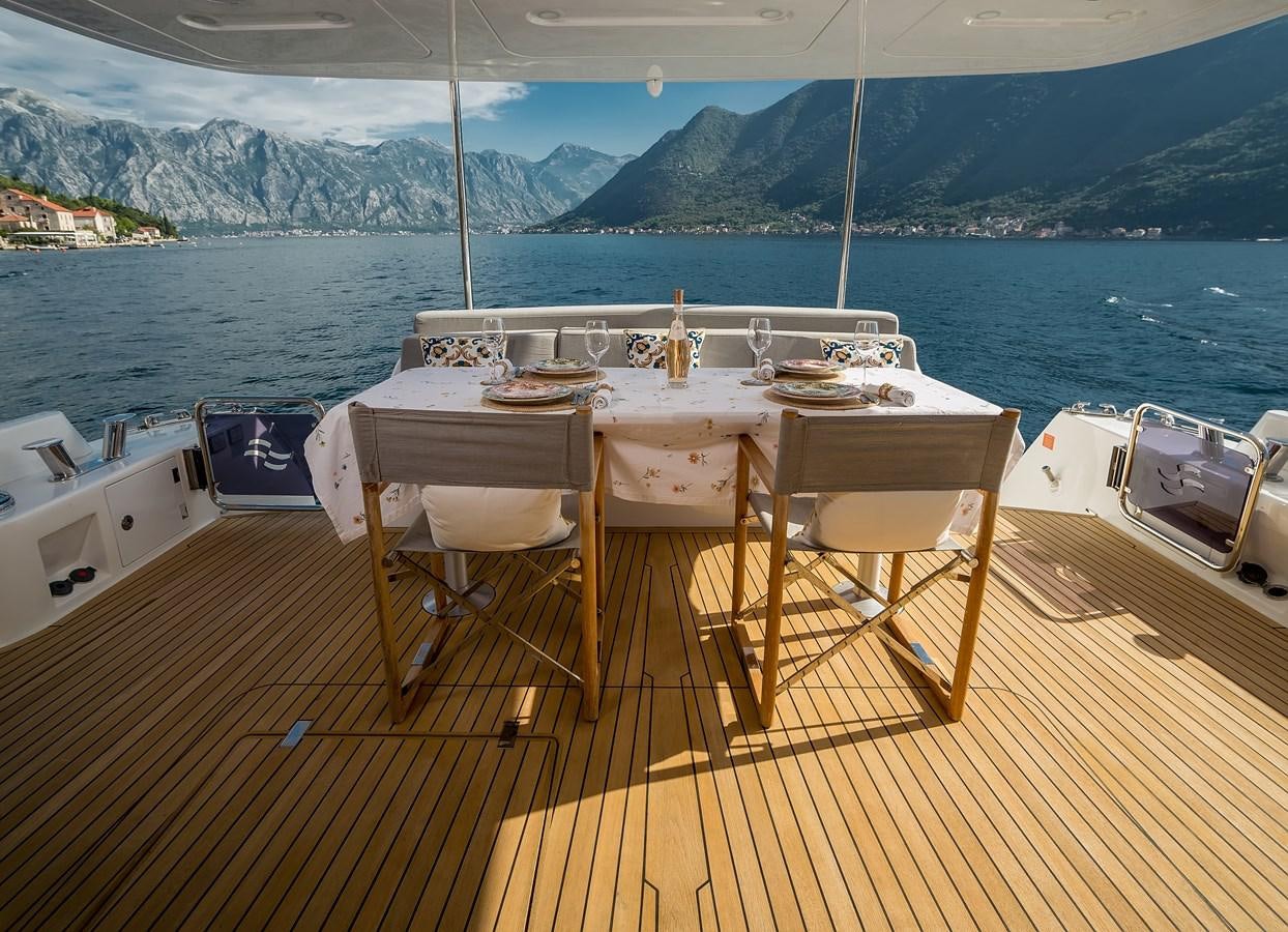 a table set on a deck overlooking a body of water aboard AVVENTURA Yacht for Sale