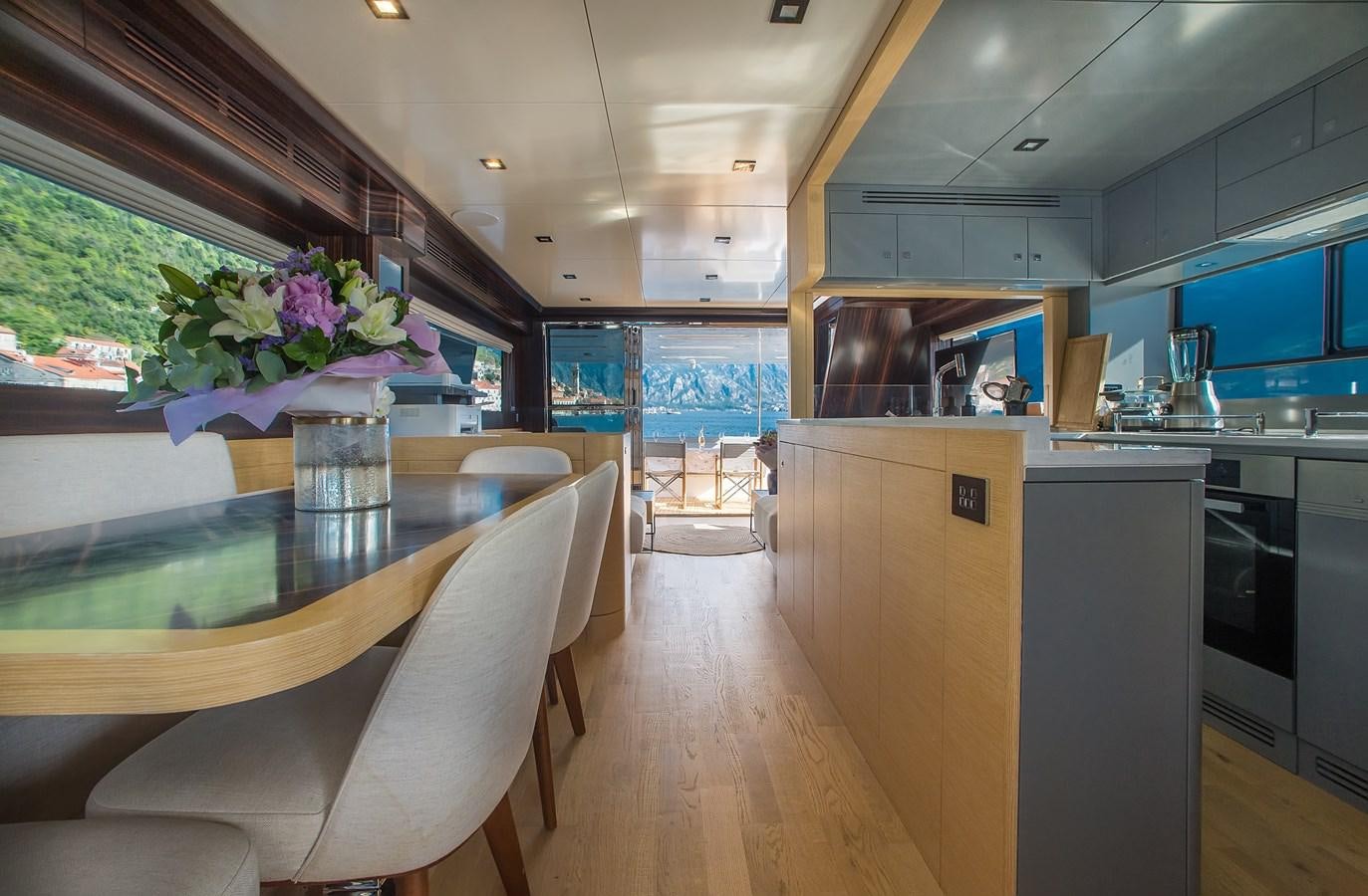 a kitchen with a table and chairs aboard AVVENTURA Yacht for Sale