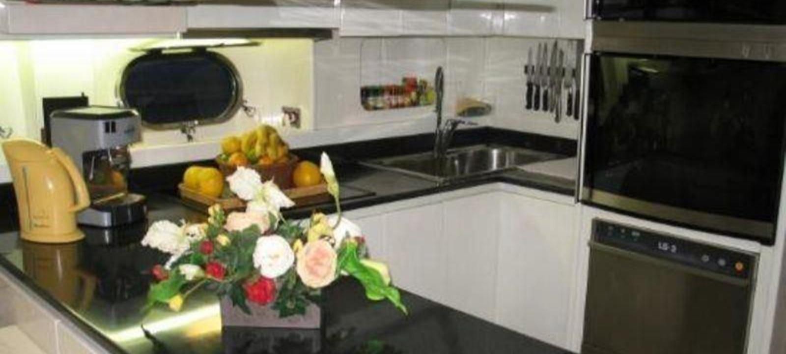 a kitchen with flowers and fruits aboard VARUNA Yacht for Sale