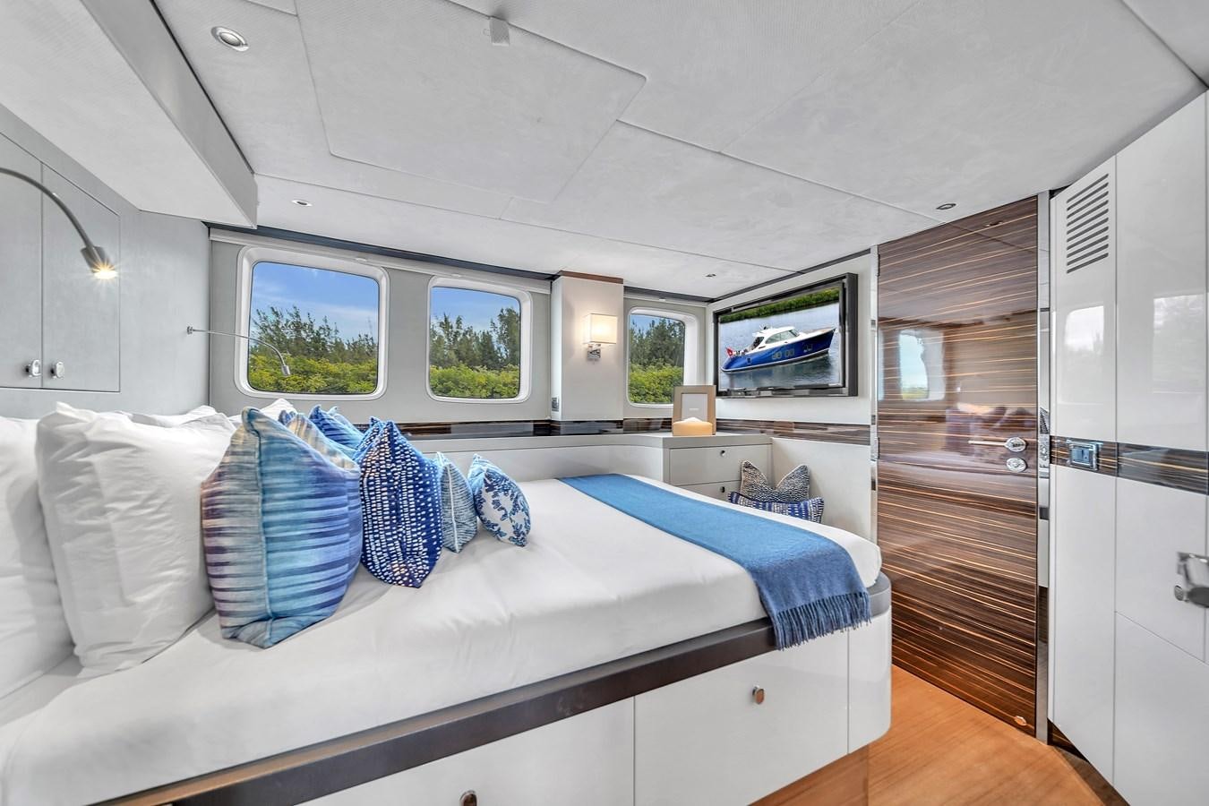 a bedroom with a bed and a wood door aboard MADDAMC2 Yacht for Sale