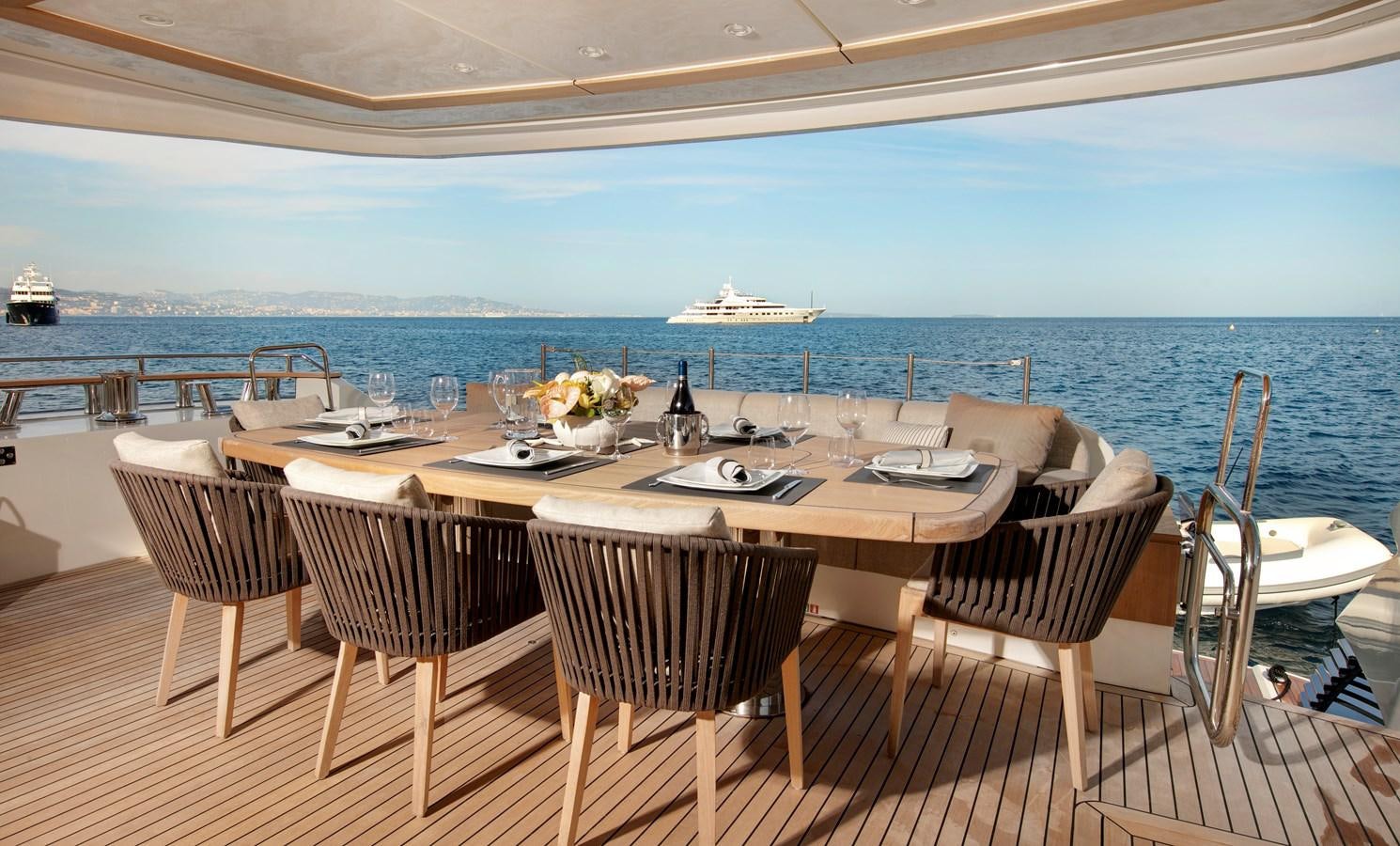 a table set for a meal on a deck overlooking the ocean aboard ESMERALDA OF THE SEAS Yacht for Sale