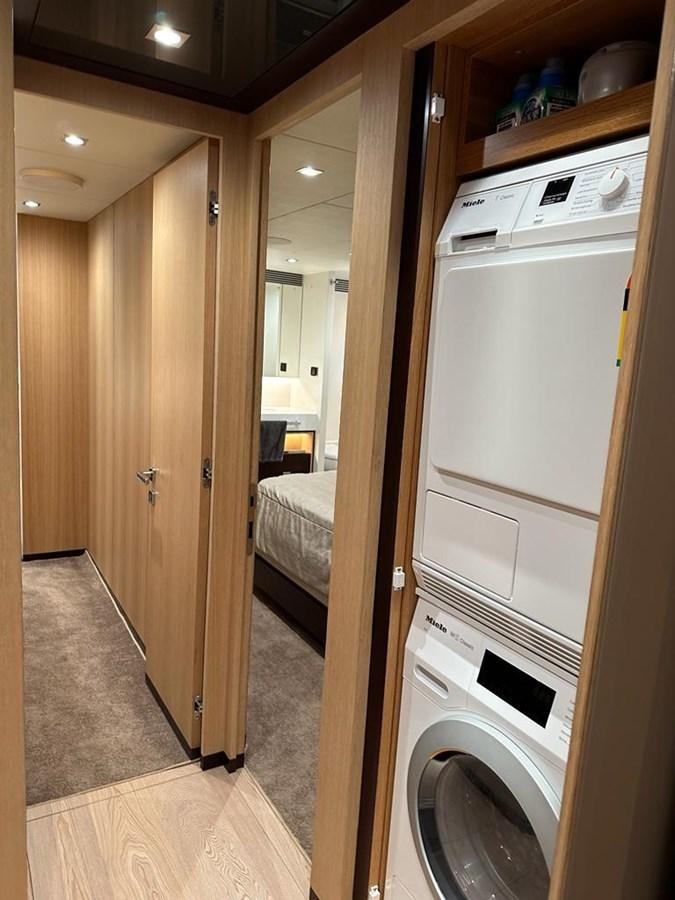 a room with a washing machine and a bed aboard BLACK SOIL Yacht for Sale