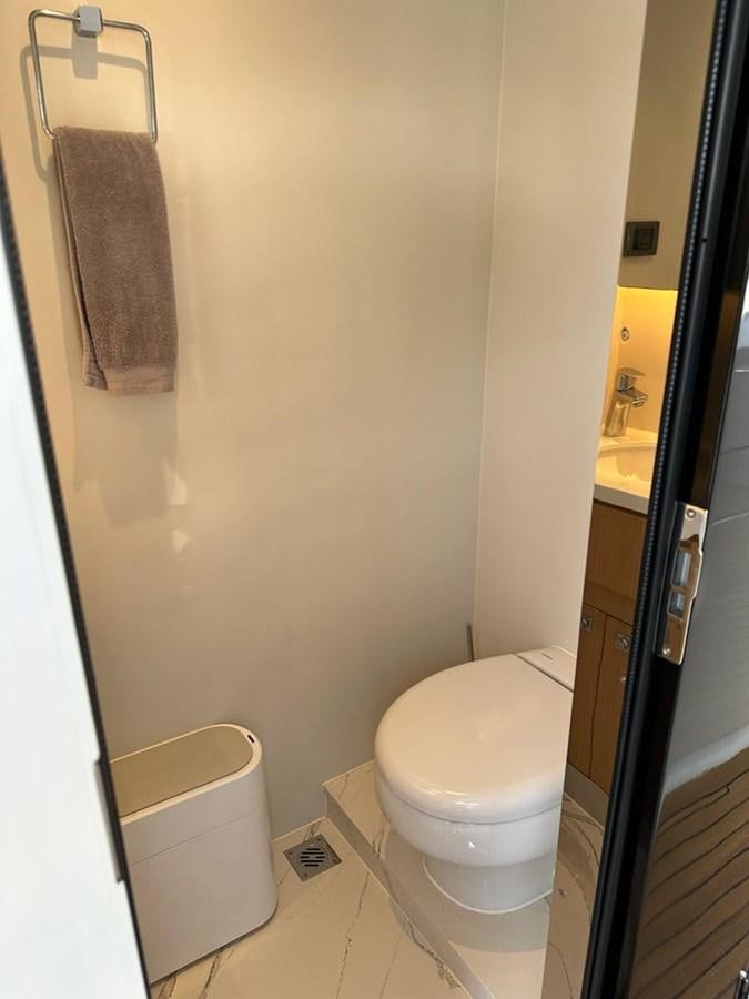 a bathroom with a toilet and a towel on the wall aboard BLACK SOIL Yacht for Sale