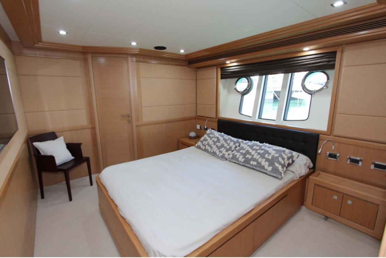 a bedroom with a bed and a chair aboard ALL WE NEED FOR TODAY Yacht for Sale