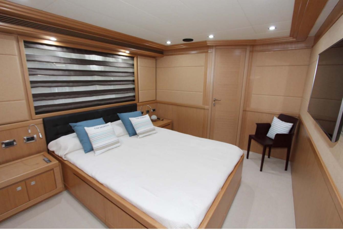 a bedroom with a bed and a chair aboard ALL WE NEED FOR TODAY Yacht for Sale