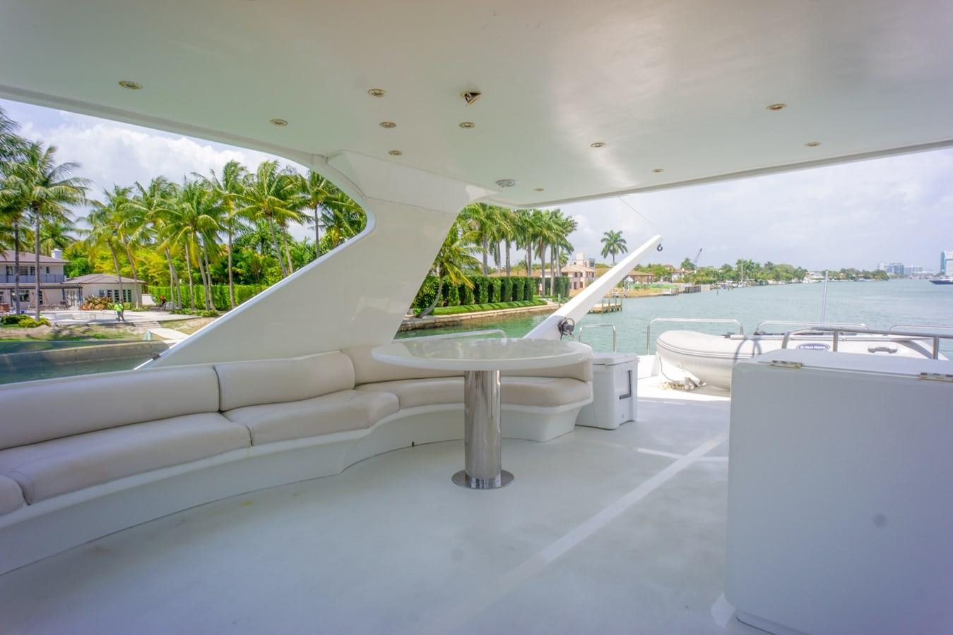 a white lounge chair next to a pool with trees and a building in the background aboard OLD SPORT II Yacht for Sale