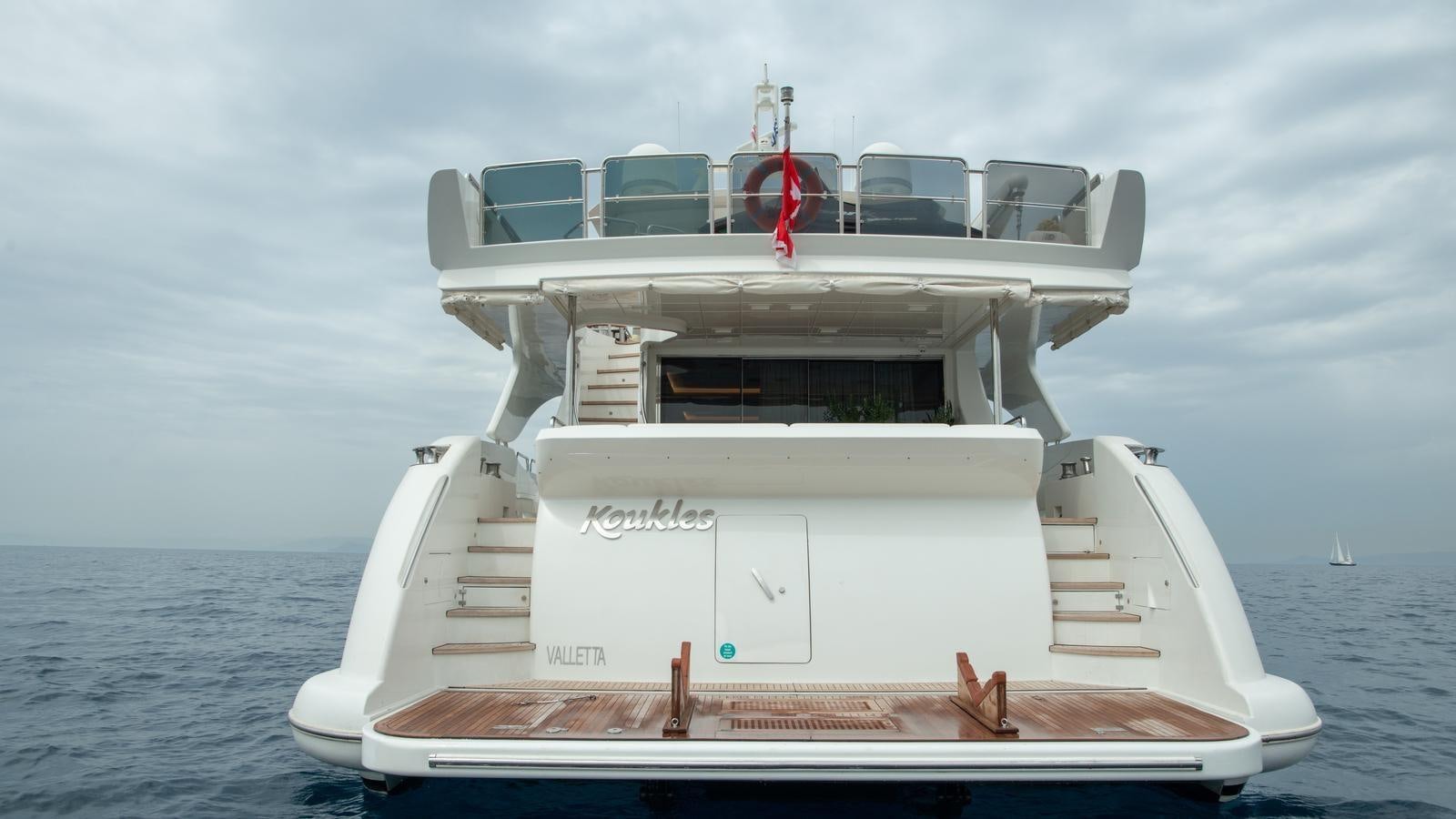a white boat with a red stripe aboard KOUKLES Yacht for Sale