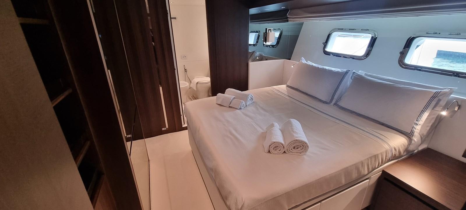 a bed with a white sheet and a white pillow on it aboard SL86 Yacht for Sale