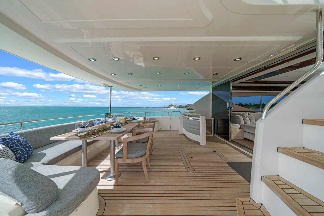 a deck with a table and chairs aboard CURRENT $EA Yacht for Sale