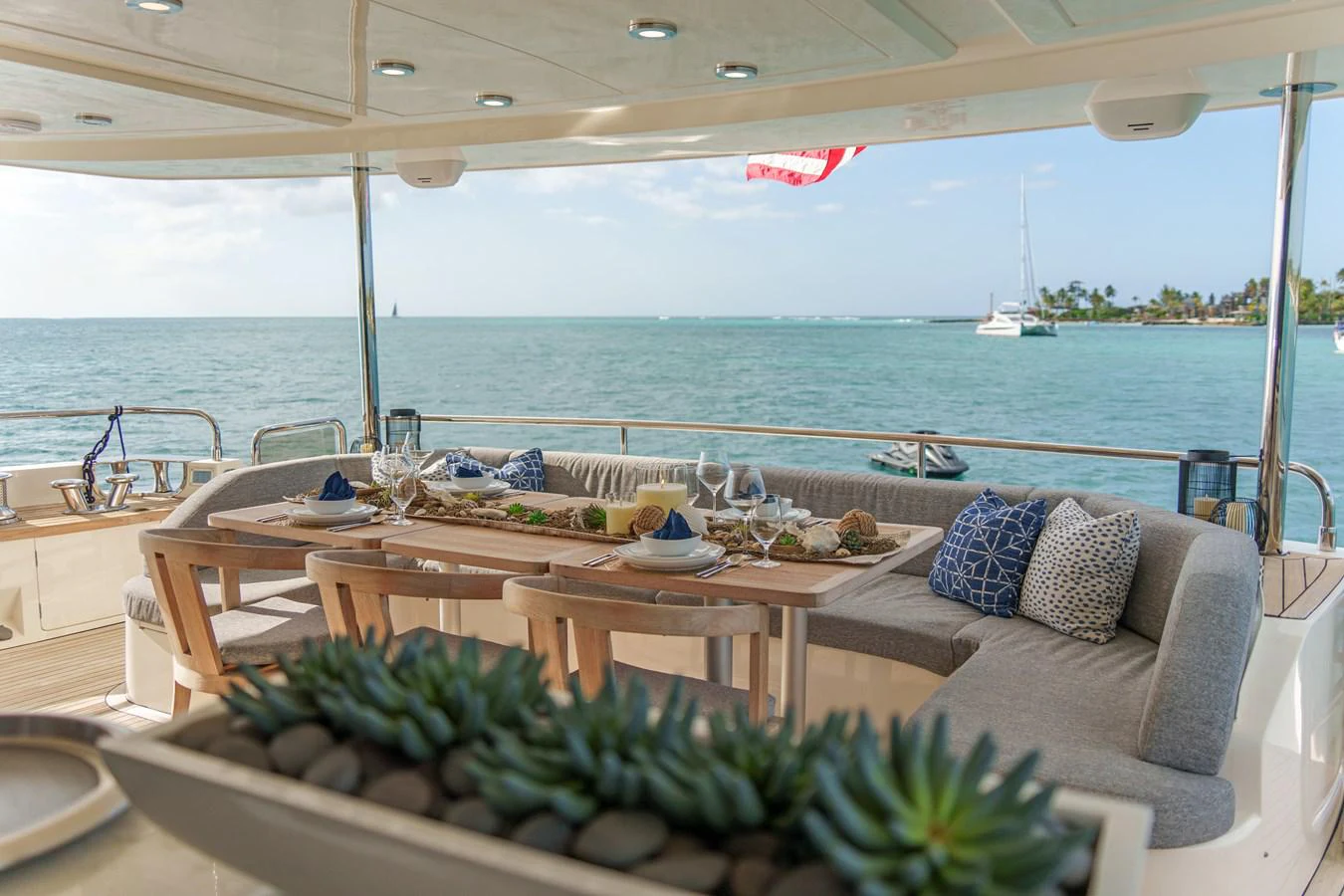 a table with plants on it by a large body of water aboard CURRENT $EA Yacht for Sale