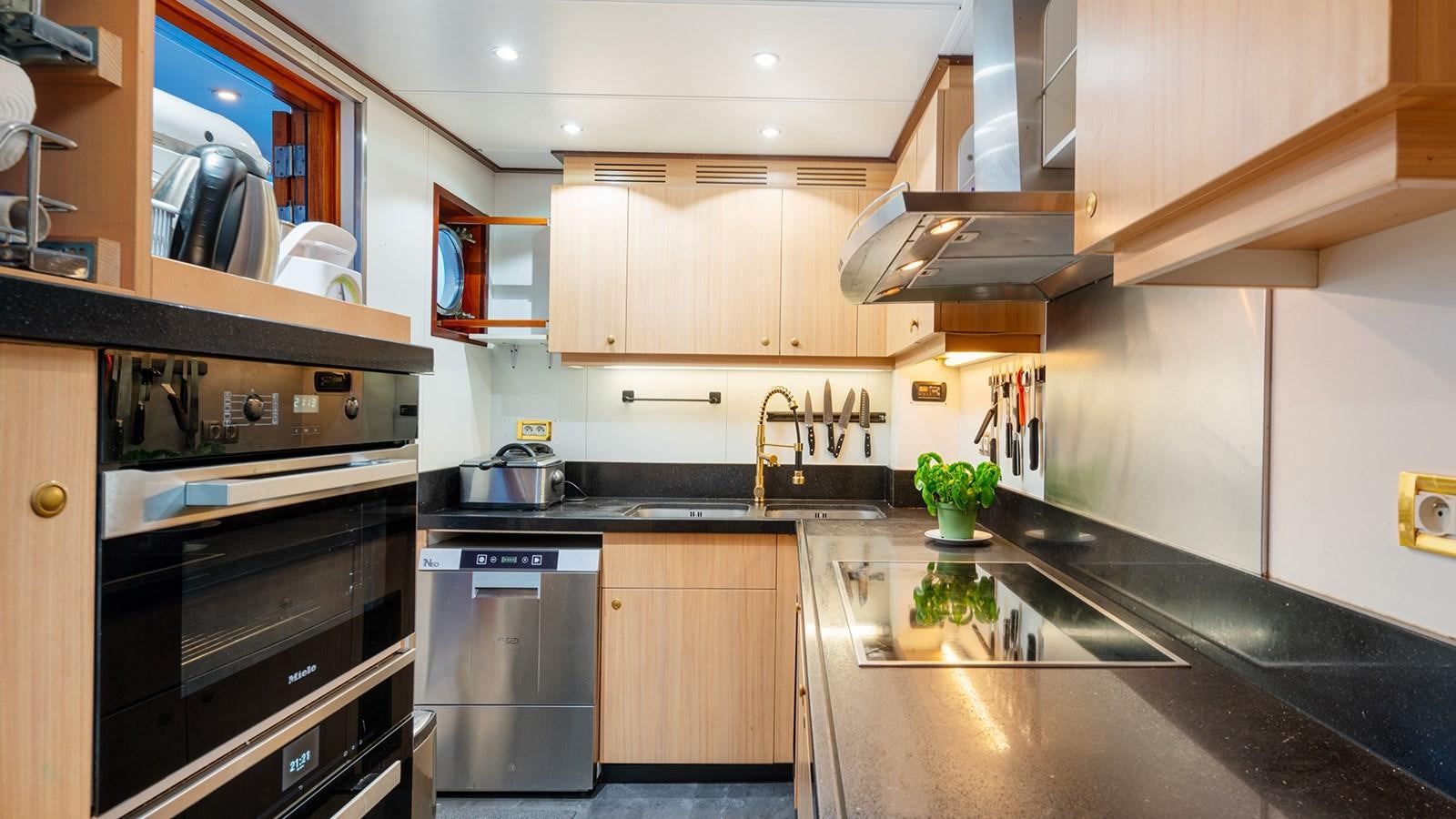 a kitchen with black appliances aboard SEA LION Yacht for Sale