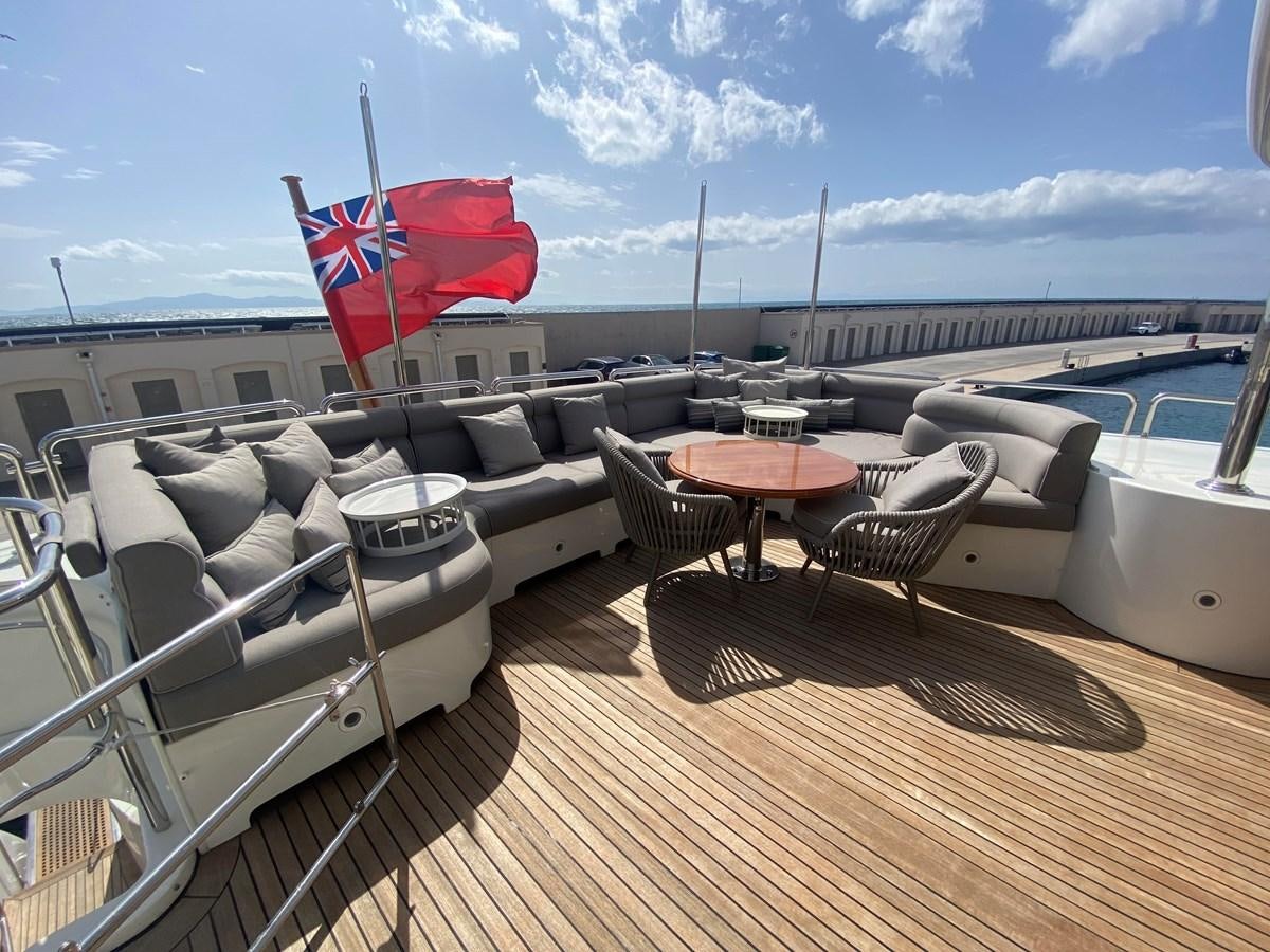 a deck with chairs and tables on it aboard B-D Yacht for Sale