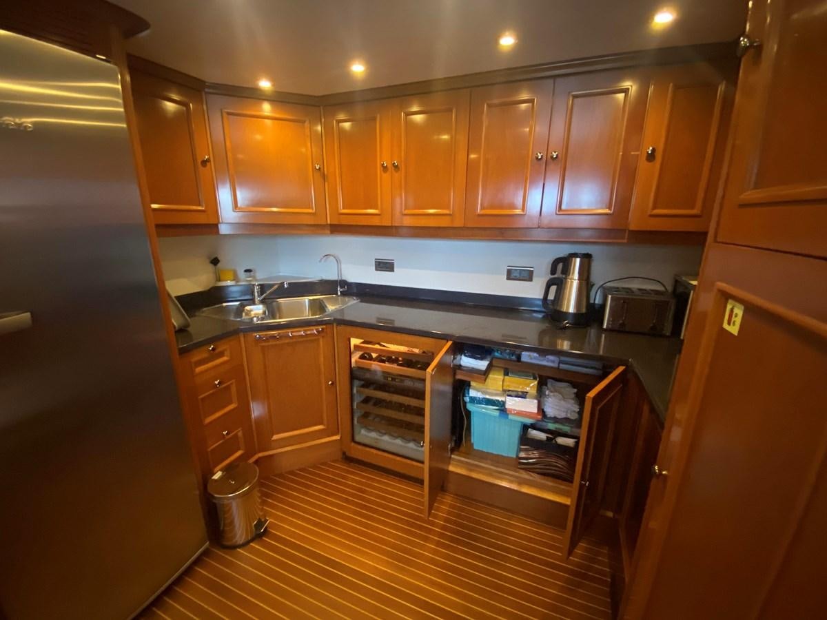 a kitchen with wooden cabinets aboard B-D Yacht for Sale