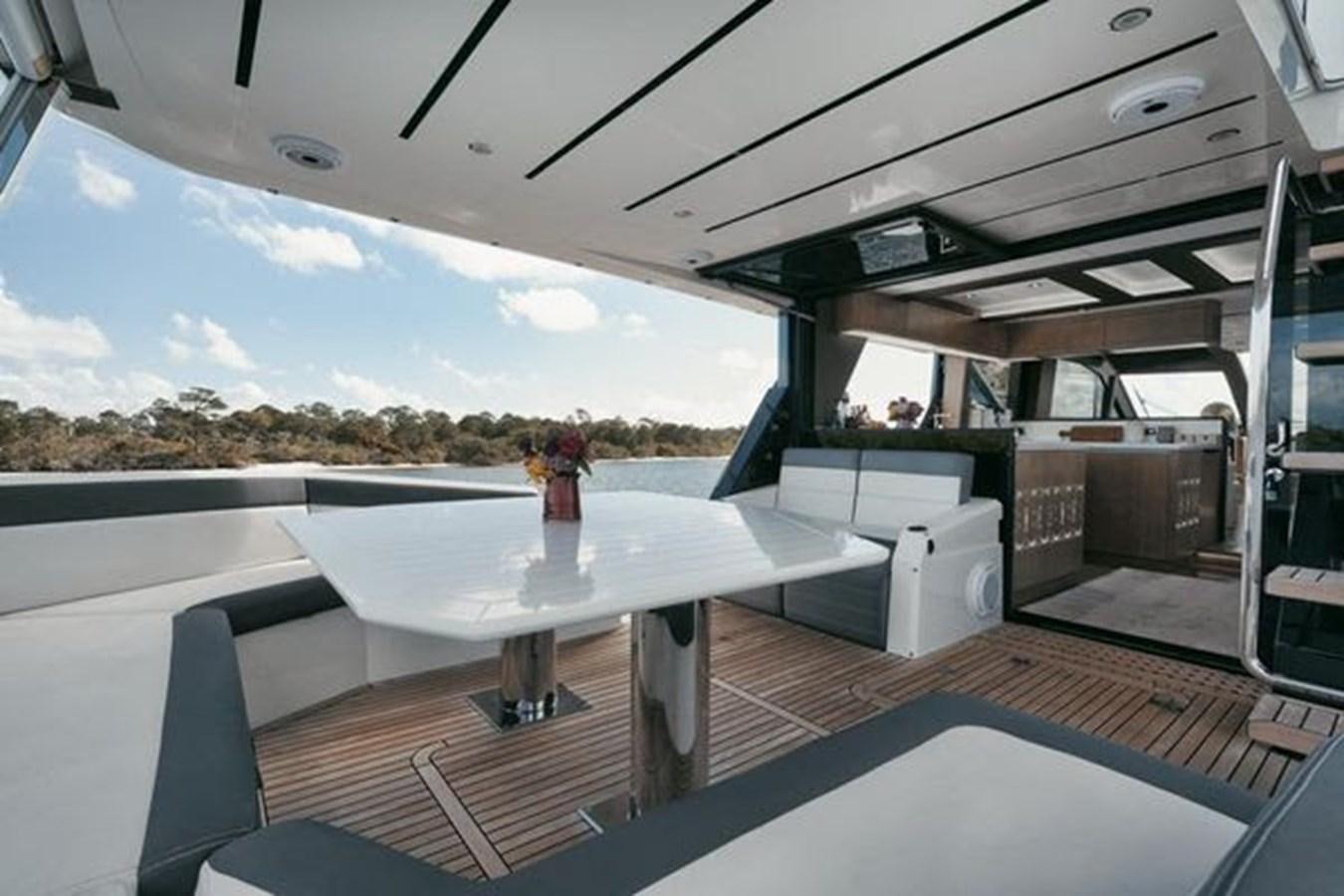 a table with chairs and a large window with a view of a city aboard JUST IN TIME Yacht for Sale