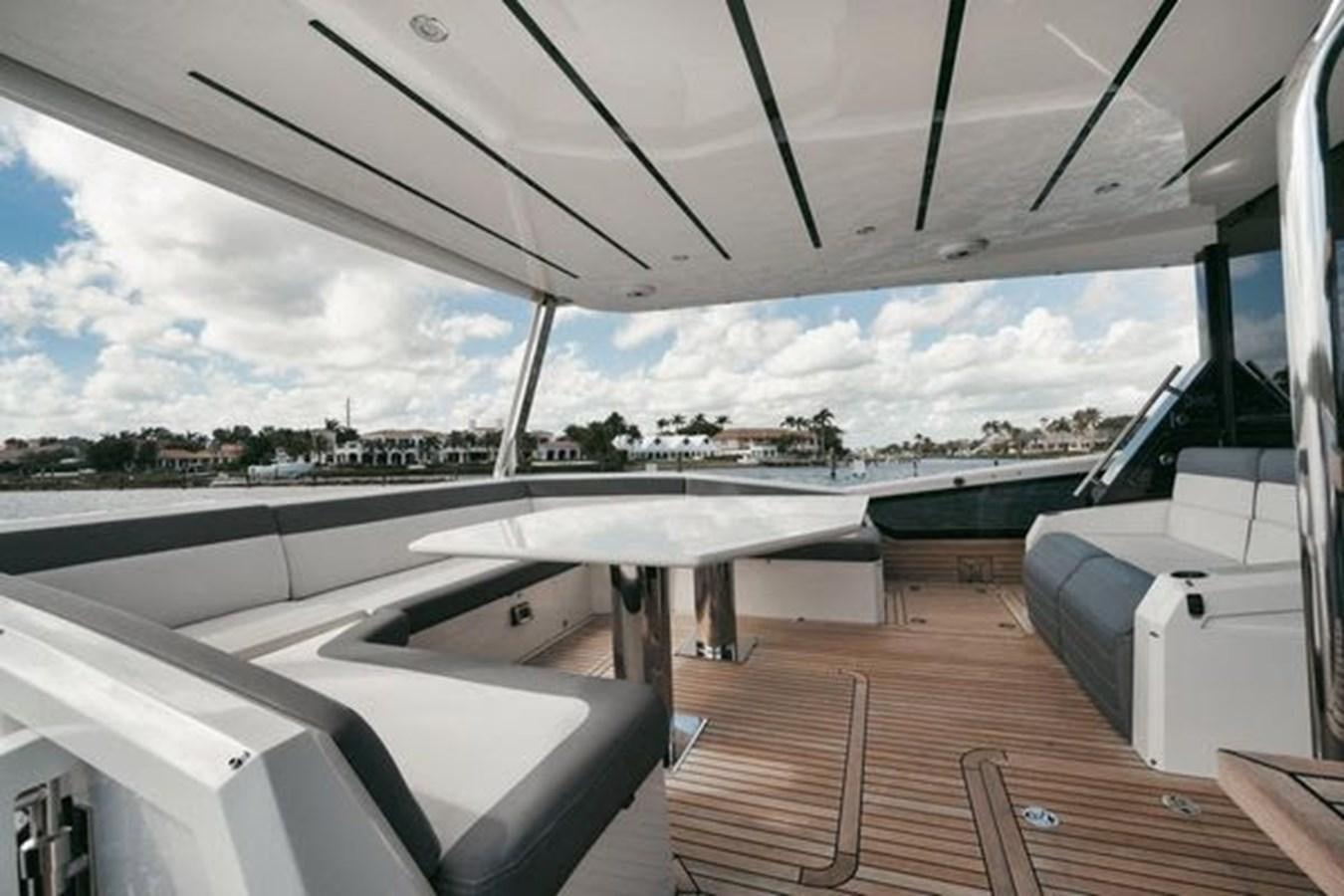 a deck with a large white boat on it and a large body of water in the background aboard JUST IN TIME Yacht for Sale
