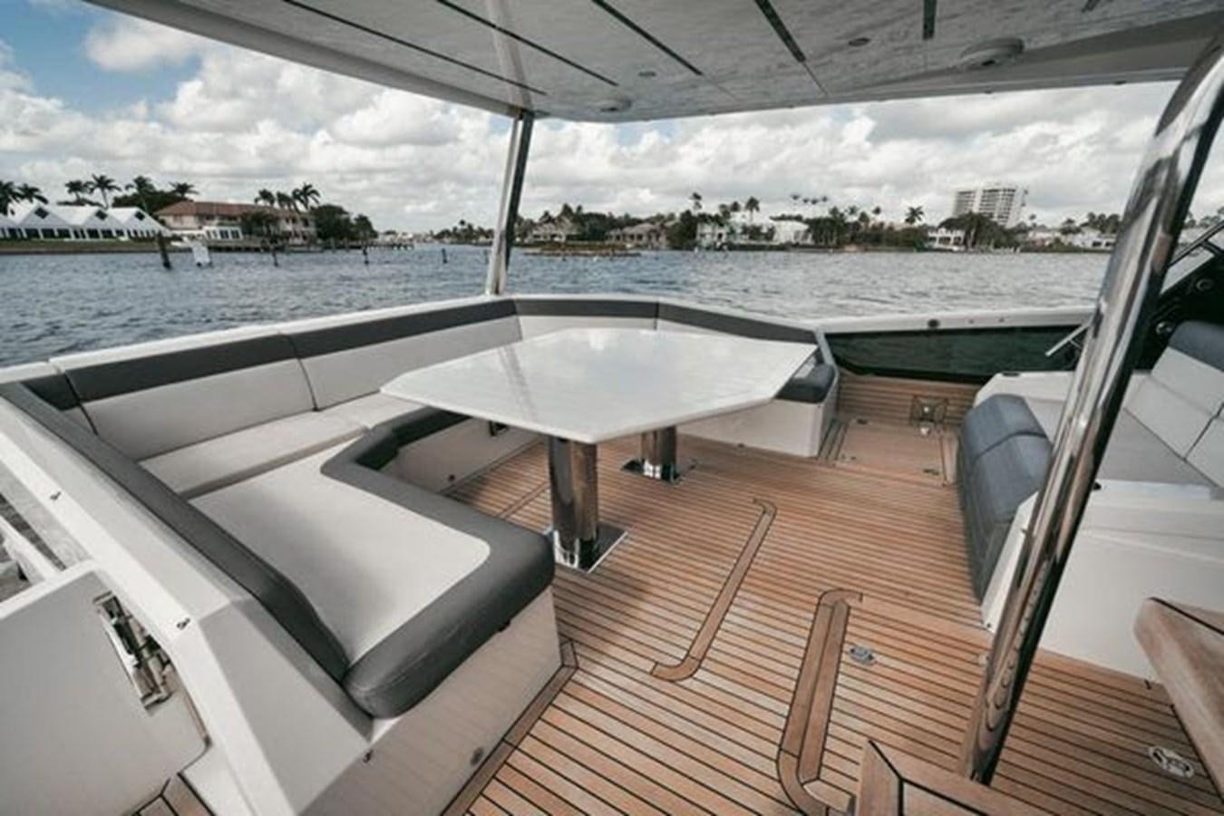 a deck with a table and chairs on it aboard JUST IN TIME Yacht for Sale