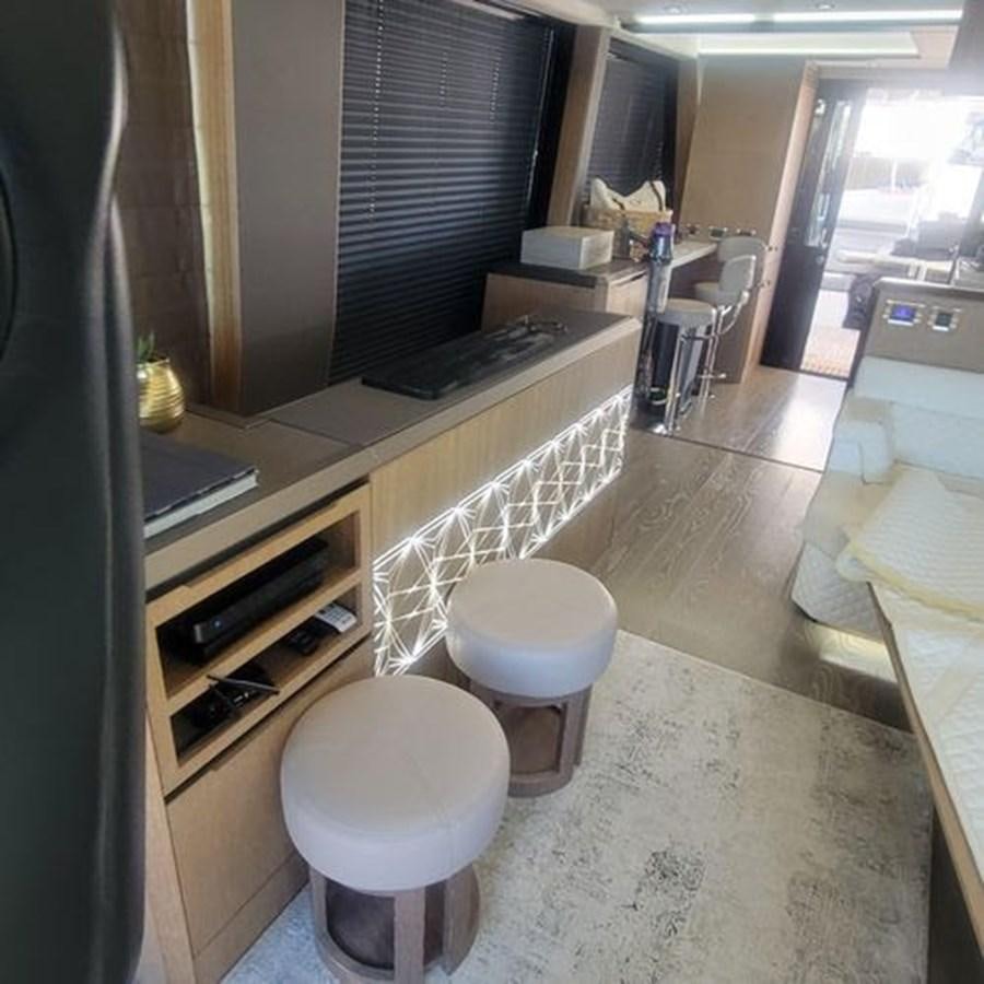 a kitchen with a bar and stools aboard JUST IN TIME Yacht for Sale